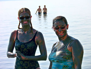 Stefanie Elkins and Jeanne DelColle encased in black Dead Sea mud (photo courtesy Stefanie Elkins)