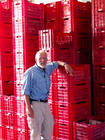 Doug Clark dwarfed by the stacks of red crates filled in the storeroom with supplies and equipment (photo courtesy Denise Herr)